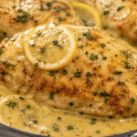 Close-up of creamy Chicken Limone with golden chicken breast, lemon slices, parsley, and rich lemon cream sauce.