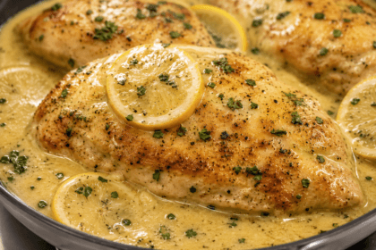 Close-up of creamy Chicken Limone with golden chicken breast, lemon slices, parsley, and rich lemon cream sauce.