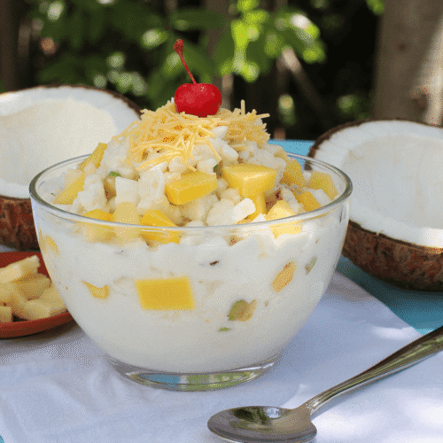 Chilled coconut milk fruit salad with nata de coco, pineapple, kaong, and shredded cheese served in a glass bowl – buko salad recipe by readyprepmeals