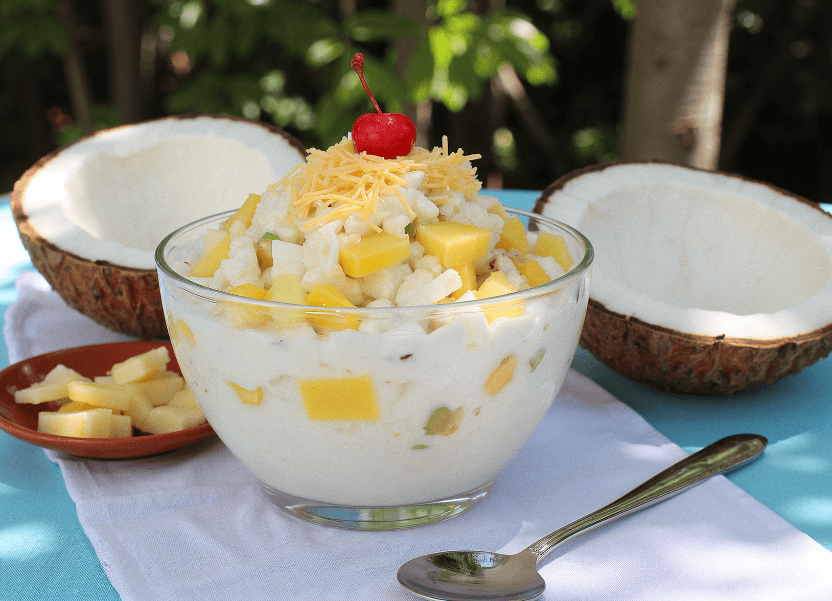 Chilled coconut milk fruit salad with nata de coco, pineapple, kaong, and shredded cheese served in a glass bowl – buko salad recipe by readyprepmeals