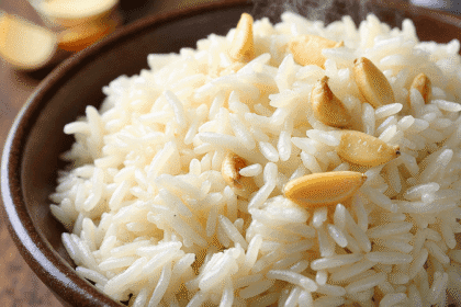 Fluffy garlic jasmine rice served in a bowl with golden fried garlic on top, styled on a rustic table – recipe by readyprepmeals
