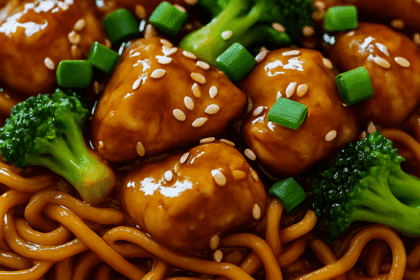 Stir-fried chicken teriyaki noodles with tender chicken, vegetables, and glossy teriyaki sauce—served in a bowl and topped with sesame seeds and green onions for a savory, high-protein meal.
