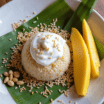 Authentic Thai mango sticky rice dessert with sliced mango and coconut cream on a banana leaf – recipe by readyprepmeals