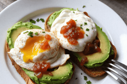 Avocado toast with poached eggs and bacon jam served on a white plate over a rustic wooden table – a perfect Father's Day breakfast idea.