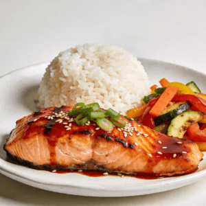 Gochujang glazed salmon served with white rice and sautéed vegetables on a plate