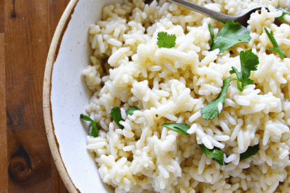 Creamy garlic coconut rice served in a rustic bowl, garnished with fresh herbs