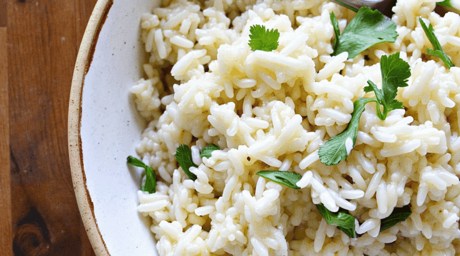 Creamy garlic coconut rice served in a rustic bowl, garnished with fresh herbs