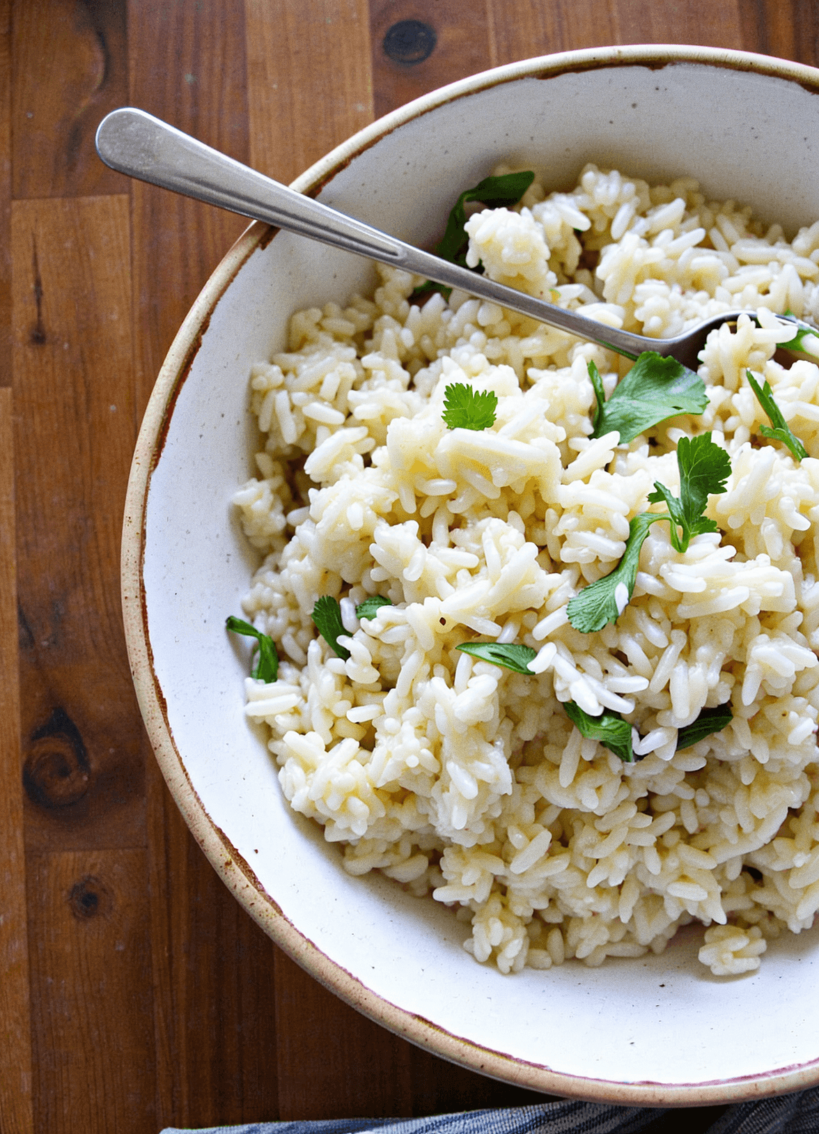 Creamy garlic coconut rice served in a rustic bowl, garnished with fresh herbs