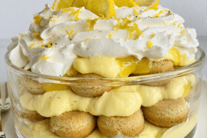 Front view of lemon tiramisu layered with mascarpone cream, ladyfingers, whipped topping, and fresh lemon slices