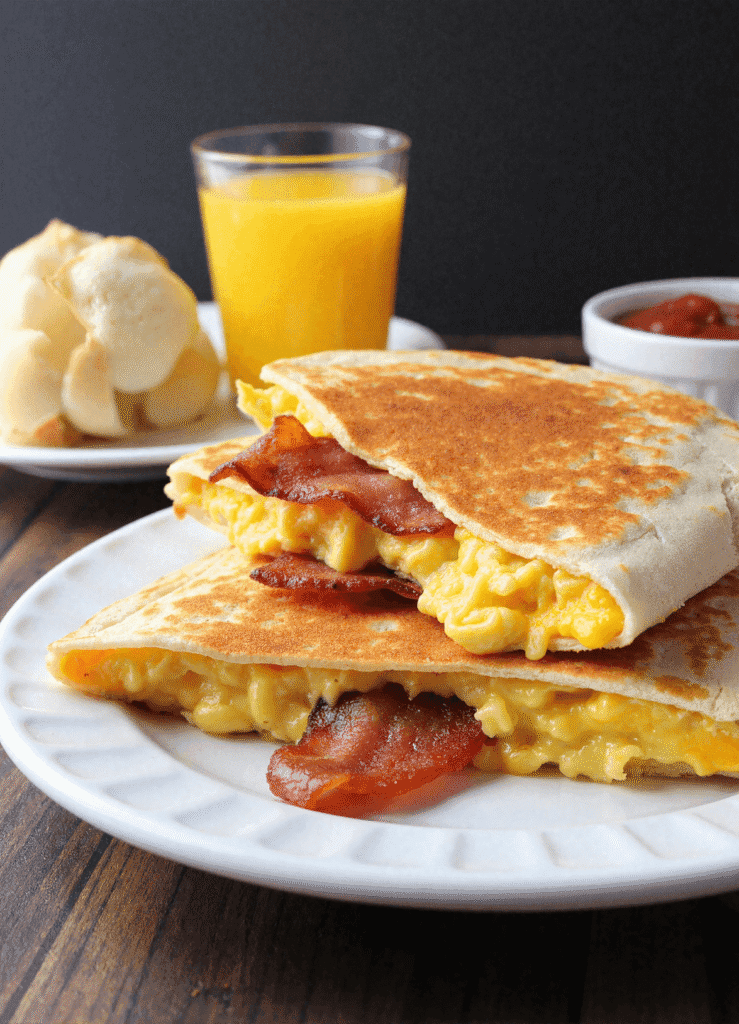 Crispy bacon egg and cheese breakfast quesadilla with golden tortilla and melted cheddar
