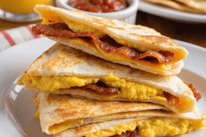 Stacked cheesy bacon egg breakfast quesadilla wedges served with salsa