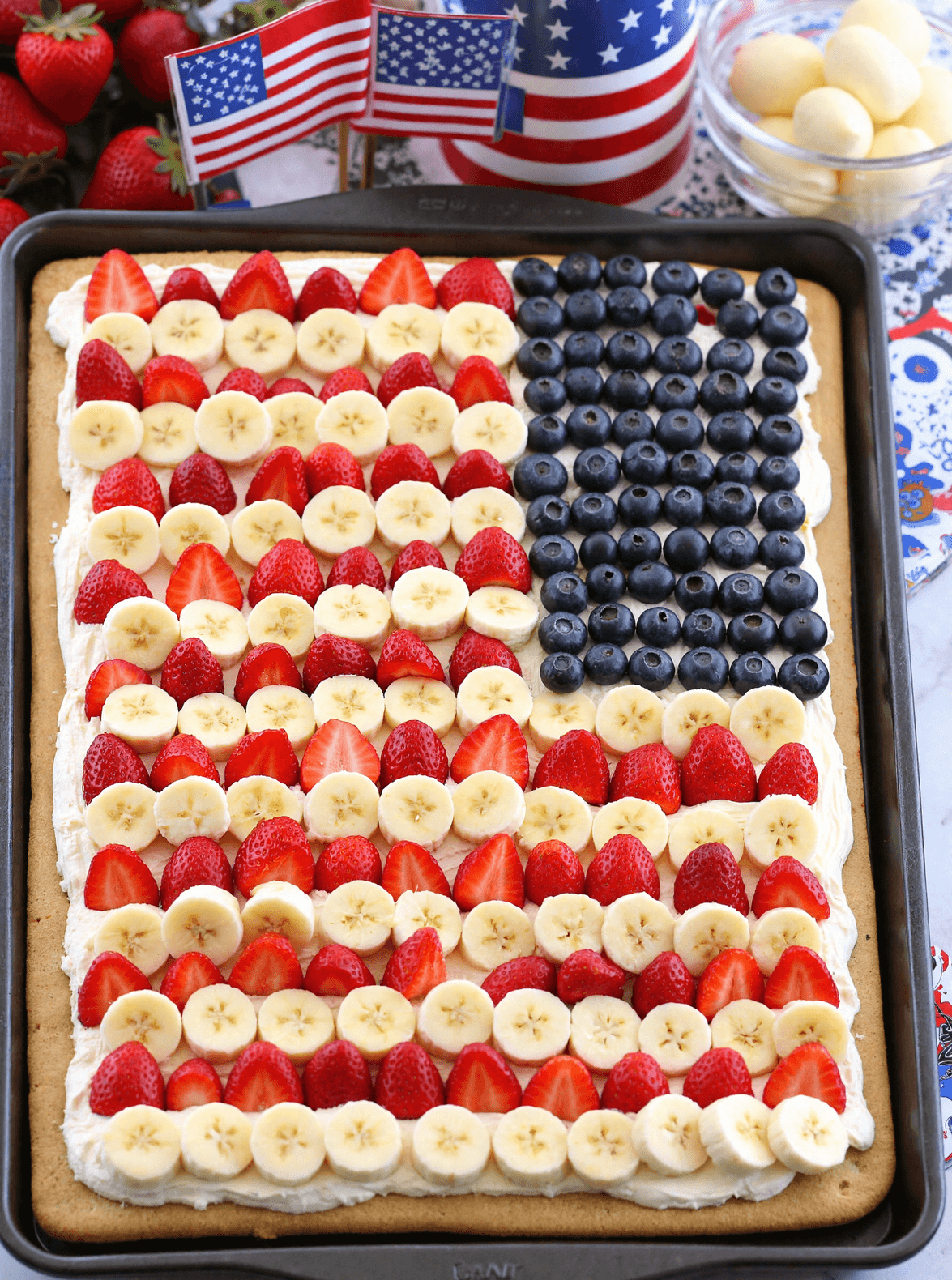 American Flag Fruit Pizza decorated with fresh strawberries, bananas, and blueberries on a sugar cookie crust for a festive 4th of July treat.