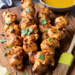 Grilled honey lime chicken skewers served on a wooden board with fresh lime wedges and cilantro