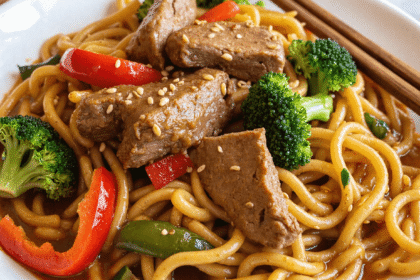 Healthy Mongolian beef noodles in sauce with broccoli, red peppers, and sesame seeds.