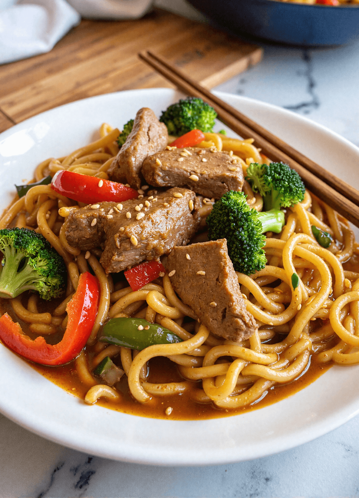 Healthy Mongolian beef noodles in sauce with broccoli, red peppers, and sesame seeds.