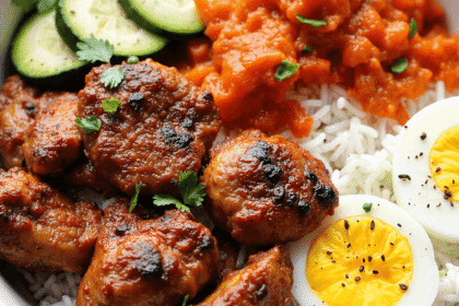 Grilled Korean BBQ chicken leg and thigh with jasmine rice, sliced cucumbers, carrots, kimchi-style mash, and soft-boiled egg.