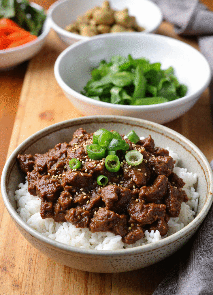 Easy Korean ground beef bowl with steamed white rice, garnished with green onions and sesame seeds.