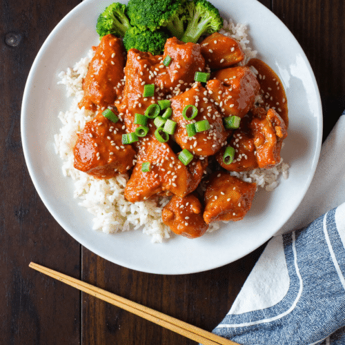 Sweet chili chicken served over steamed white rice with broccoli and sesame seeds