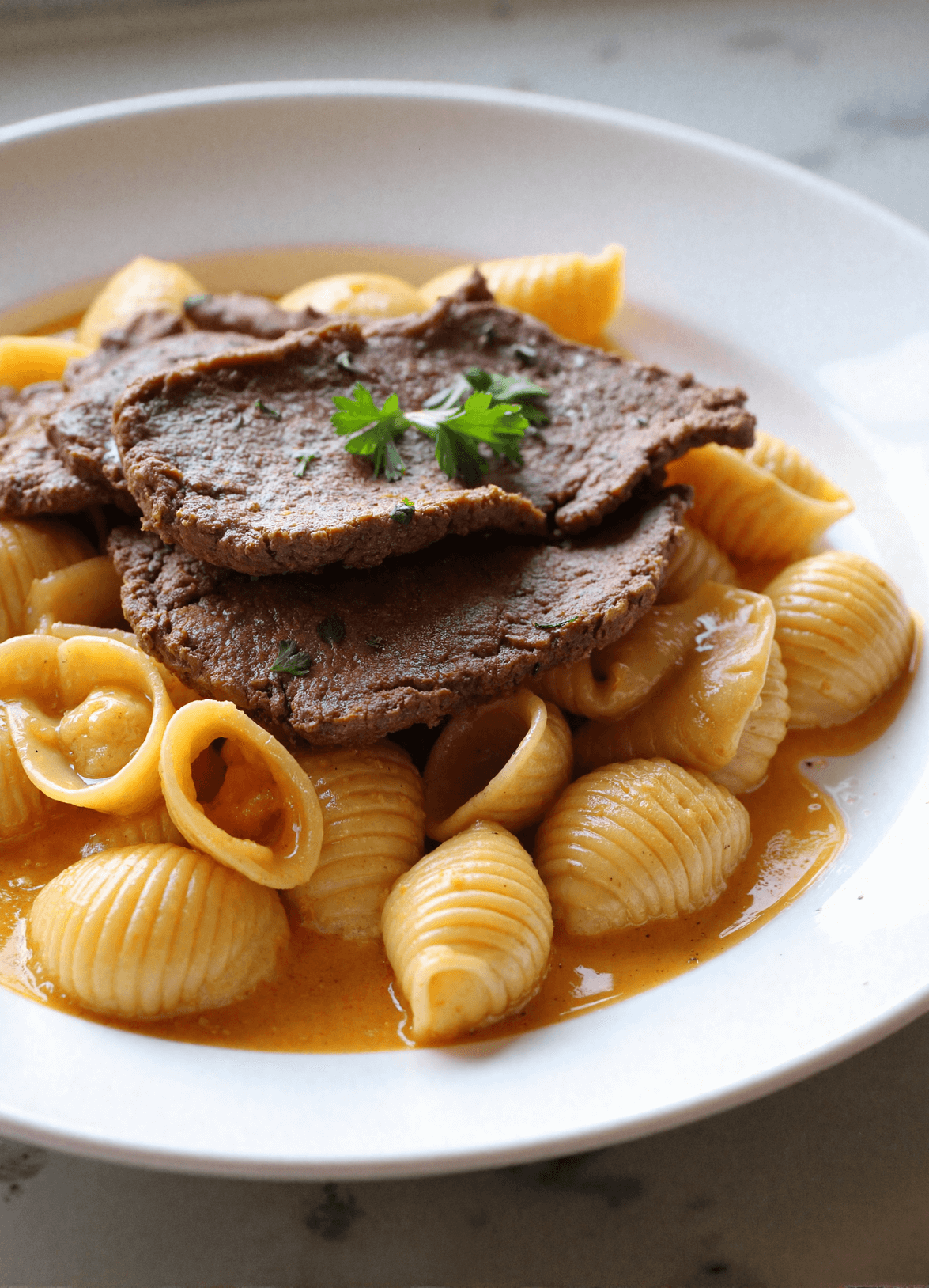 Tender slices of seared steak on top of creamy paprika pasta shells coated in garlic cream sauce.