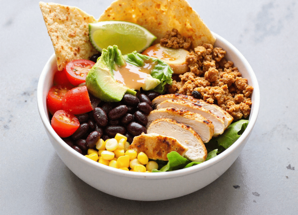 Southwest salad bowl with grilled chicken, black beans, avocado, cherry tomatoes, corn, and chipotle dressing.