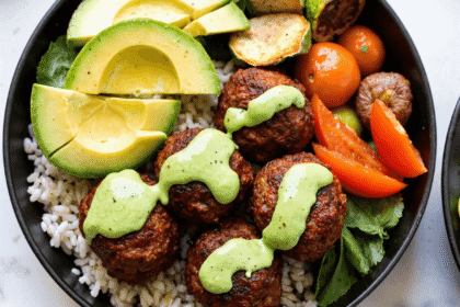High-protein barbecue meatball bowl with avocado slices, rice, fresh vegetables, and creamy avocado goddess sauce.