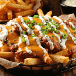 Cajun voodoo fries topped with spicy chicken, melted cheese, creamy ranch, and green onions.