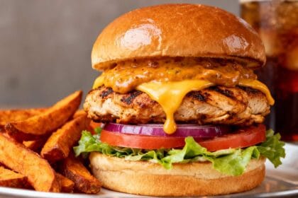 Grilled chipotle chicken burger with cheddar cheese, smoky chipotle sauce, lettuce, tomato, onion, and brioche bun served with sweet potato fries.