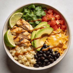 Top view of a healthy chicken enchilada bowl with cauliflower rice, grilled chicken, avocado, cheese, and enchilada sauce