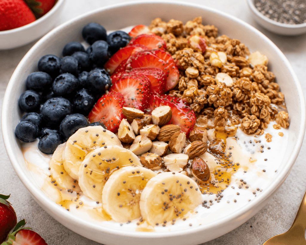 Greek Yogurt Power Bowl topped with fresh berries, banana slices, granola, almonds, chia seeds, and honey for a protein-packed healthy breakfast.