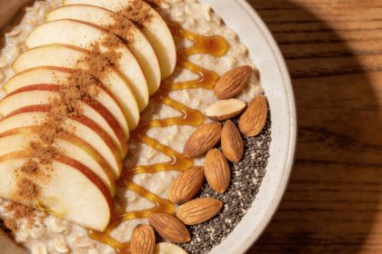 Top view of apple cinnamon oatmeal with sliced apples honey and almonds in a bowl