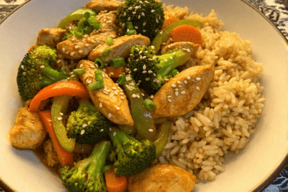 High-protein chicken stir fry with brown rice broccoli bell peppers and carrots in a bowl