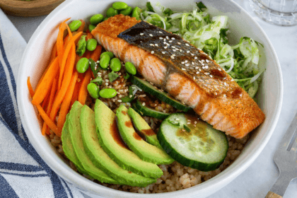 High-protein salmon rice bowl with crispy skin salmon avocado cucumber and vegetables