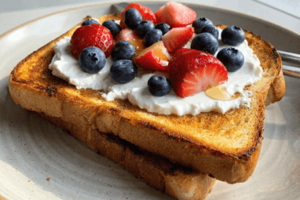 High-protein yogurt toast topped with strawberries blueberries and honey on crispy golden bread