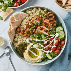 Top view of chicken shawarma bowl with grilled chicken, rice, vegetables, and pita