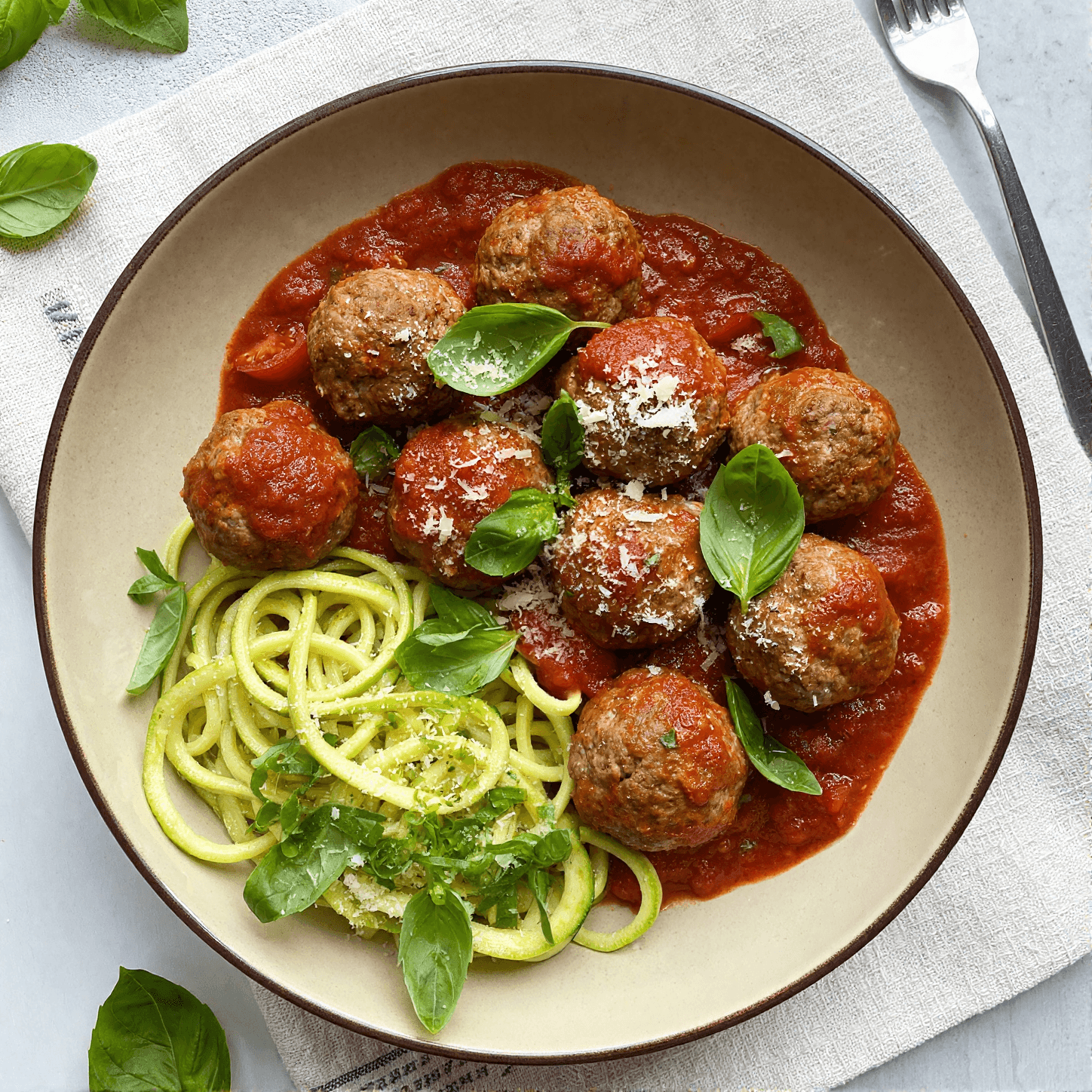 Top view of turkey meatball marinara with basil and parmesan in tomato sauce