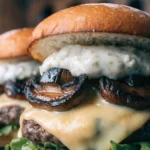 Close-up of a grilled mushroom Swiss burger with melted Swiss cheese, garlic aioli, and caramelized mushrooms on a toasted bun.